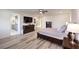 Well-lit main bedroom with hardwood floors, a ceiling fan, and an ensuite bathroom at 5328 Hickory Tree St, Las Vegas, NV 89149