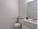 Well-lit half bathroom with single sink, toilet, and mirror at 5600 Grossmont Ave, Las Vegas, NV 89110