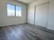 Bedroom with wood floors, window, and a sliding door closet at 5600 Grossmont Ave, Las Vegas, NV 89110