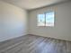 Bright bedroom featuring laminate flooring, a window with a beautiful view, and fresh paint at 5600 Grossmont Ave, Las Vegas, NV 89110
