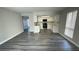 Open-concept living space with gray wood-look flooring and updated kitchen at 5720 Goldmount Ave, Las Vegas, NV 89107