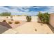 Desert landscaping with gravel, cacti, and bushes, enclosed by a white stucco wall at 6 Sandwedge Dr, Henderson, NV 89074