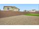 Enclosed backyard with an artificial lawn surrounded by gravel at 6830 Fallen Rock St, North Las Vegas, NV 89084