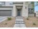 A close up of the front entrance showing the stone facade, pathway, and modern gray door at 6830 Fallen Rock St, North Las Vegas, NV 89084