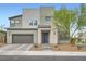 A modern two-story home with a gray exterior, complemented by a stone entrance and well-maintained landscaping at 6830 Fallen Rock St, North Las Vegas, NV 89084
