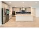 The kitchen features stainless appliances, a large island, and stylish tiled backsplash at 6830 Fallen Rock St, North Las Vegas, NV 89084