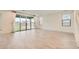 Spacious open-concept living room with sliding glass doors, neutral paint and tile at 6830 Fallen Rock St, North Las Vegas, NV 89084