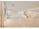 An open living space with large sliding glass doors, neutral tile flooring and a staircase to the second floor at 6830 Fallen Rock St, North Las Vegas, NV 89084