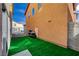 View of the backyard featuring artificial turf, adjacent to a stucco wall and gated area at 687 Porchtown Ave, Las Vegas, NV 89183