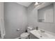 Small half bathroom featuring a toilet, vanity with sink, mirror and gray walls at 687 Porchtown Ave, Las Vegas, NV 89183
