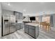 Bright kitchen featuring stainless steel refrigerator, island, gray cabinets, and adjacent dining area at 687 Porchtown Ave, Las Vegas, NV 89183