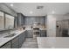 Beautiful kitchen with gray cabinets, an island, stainless steel appliances, and luxury vinyl plank flooring at 687 Porchtown Ave, Las Vegas, NV 89183