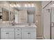 Bright bathroom with dual sinks, large mirror, and a tiled shower at 688 Monroe Hill Pl, Henderson, NV 89011