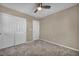 Cozy bedroom featuring a ceiling fan, plush carpet, neutral paint, and a closet with double doors at 688 Monroe Hill Pl, Henderson, NV 89011
