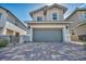 Two-story home features a two car garage and a beautiful brick driveway and mature landscaping in the front yard at 688 Monroe Hill Pl, Henderson, NV 89011