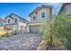 Two-story home with a charming brick driveway, a two car garage and mature landscaping in the front yard at 688 Monroe Hill Pl, Henderson, NV 89011