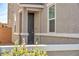 The front of this charming home features a gray stucco and a dark front door at 688 Monroe Hill Pl, Henderson, NV 89011