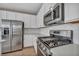 Modern kitchen featuring stainless steel appliances and sleek white cabinetry at 688 Monroe Hill Pl, Henderson, NV 89011