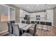 Open-concept kitchen and dining area features sleek white cabinets, stainless steel appliances, and modern lighting at 688 Monroe Hill Pl, Henderson, NV 89011