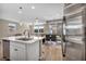 Open kitchen and living area with modern lighting and stainless steel refrigerator at 688 Monroe Hill Pl, Henderson, NV 89011