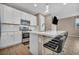 Modern kitchen features stainless steel appliances, white cabinets, island with seating, and stylish pendant lighting at 688 Monroe Hill Pl, Henderson, NV 89011