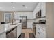 Well-lit kitchen with stainless steel appliances, white cabinetry, and easy access to the dining space at 688 Monroe Hill Pl, Henderson, NV 89011