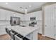 Modern kitchen featuring white cabinets, stainless steel appliances, quartz countertops, and stylish lighting at 688 Monroe Hill Pl, Henderson, NV 89011