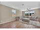 Spacious living room with a comfortable sectional sofa, wood floors and lots of natural light from the windows at 688 Monroe Hill Pl, Henderson, NV 89011