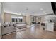 Open-concept living room with a large sectional sofa, wood floors, and a modern ceiling fan and recessed lights at 688 Monroe Hill Pl, Henderson, NV 89011