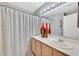 Cozy bathroom featuring a vanity with a sink, a large mirror, and a shower/tub with patterned curtain at 701 Wheat Ridge Ln # 203, Las Vegas, NV 89145