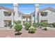 A symmetric exterior of the apartments highlighting manicured lawn, and well-maintained plants in front of the building at 701 Wheat Ridge Ln # 203, Las Vegas, NV 89145