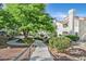 A beautiful exterior view showing manicured lawns, winding sidewalks, and lush trees in front of the apartments at 701 Wheat Ridge Ln # 203, Las Vegas, NV 89145