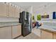Modern kitchen with stainless steel refrigerator, light wood cabinets, and granite countertops at 701 Wheat Ridge Ln # 203, Las Vegas, NV 89145
