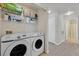 Convenient laundry room with washer, dryer, and shelving for cleaning supplies at 701 Wheat Ridge Ln # 203, Las Vegas, NV 89145