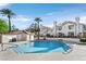 Relaxing community pool with clear blue water, palm trees, and well-maintained landscaping at 701 Wheat Ridge Ln # 203, Las Vegas, NV 89145