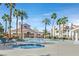 Community pool area with palm trees, lounge chairs, and a clear blue swimming pool at 701 Wheat Ridge Ln # 203, Las Vegas, NV 89145