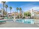 Inviting community pool area with palm trees, lounge chairs, and a covered seating area at 701 Wheat Ridge Ln # 203, Las Vegas, NV 89145