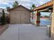 Tan backyard shed with a heat lamp and partial view of the pickleball court at 7020 King Solomons Ct, Las Vegas, NV 89117
