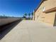 Large paved driveway leading to the side of a tan-colored home with a tile roof at 7020 King Solomons Ct, Las Vegas, NV 89117