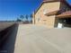 Extended driveway beside a tan home with a tile roof and brick planter at 7020 King Solomons Ct, Las Vegas, NV 89117