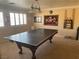 Bright game room featuring two large windows, a unique light fixture, and a table tennis setup at 7020 King Solomons Ct, Las Vegas, NV 89117