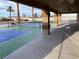Covered patio and pickleball court with ceiling fans, columns, and beautiful landscaping at 7020 King Solomons Ct, Las Vegas, NV 89117