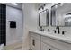 Modern bathroom featuring double sinks, black hardware, and a black tiled shower at 706 Greenway Rd, Henderson, NV 89002