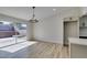 Bright dining area with wood-look floors, modern light fixture, and sliding glass doors to the backyard patio at 706 Greenway Rd, Henderson, NV 89002