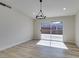 Bright dining area with wood-look floors, modern light fixture, and sliding glass doors to the backyard at 706 Greenway Rd, Henderson, NV 89002