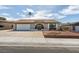 Single-story home with desert landscaping, arched entryway, and two-car garage on a sunny day at 706 Greenway Rd, Henderson, NV 89002