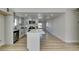 Spacious kitchen with stainless steel appliances, white cabinets and a center island open to a large dining area at 706 Greenway Rd, Henderson, NV 89002
