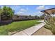 Expansive backyard featuring a well-maintained lawn, desert landscaping, and a covered patio at 7228 Fern Meadow St, Las Vegas, NV 89149