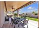 Covered patio area with outdoor dining, ceiling fans, and well-maintained landscaping at 7228 Fern Meadow St, Las Vegas, NV 89149