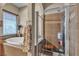 This bathroom has a tub, glass enclosed shower with bench, and natural light from a window at 7228 Fern Meadow St, Las Vegas, NV 89149